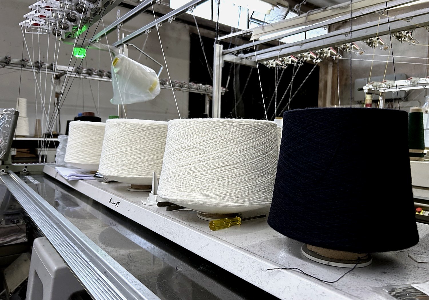 Cones de fio branco e azul escuro em produção